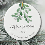 Adorno De Cerámica Nuestra primera Navidad casada<br><div class="desc">Celebra tu primera Navidad como una pareja comprometida con este elegante adorno de cerámica. Está decorada con mistletoe acuarela y elegante tipografía de escritura. Personalizable fácil. Utilice la Herramienta de diseño para cambiar el tamaño,  estilo o color del texto. Acuarela original © Michele Davies.</div>