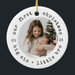 Adorno De Cerámica Nuestra primera Navidad como Gran Hermana y Fotos<br><div class="desc">Celebra una dulce primera Navidad para los nuevos hermanos. Este adorno fotográfico redondo presenta una acogedora apariencia de papel-kraft, un texto curvo de "nuestra primera navidad" y una ventana de retrato perfecta para una hermana mayor que sostiene a su hermano bebé. Ideal para fotos de recién nacidos, regalos familiares y...</div>