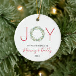 Adorno De Cerámica Nuestra primera Navidad, mamá y papá Joy Wreath<br><div class="desc">Elegante ornamento de vacaciones con "JOY" con las letras "J" e "Y" en una letra roja sans serif y una acuarela pintada de vegetación como la letra "O". Debajo está "Nuestra primera Navidad como mamá y papá" junto con el año. Este adorable adorno es un regalo perfecto para los nuevos...</div>