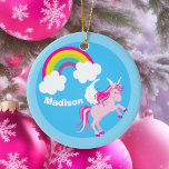 Adorno De Cerámica Personalizado del arcoiris de Unicornio<br><div class="desc">Un hermoso y caprichoso regalo de Navidad para un chica que ama los regalos personalizados bonitos. Un unicornio rosa lindo con alas blancas saltando al aire al lado de un hermoso arcoiris sobre el fondo del cielo. Personalizar con su nombre.</div>