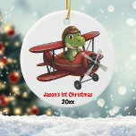 Adorno De Cerámica Personalizado, dinosaurio de avión pequeño, primer<br><div class="desc">El diseño presenta un lindo dinosaurio con un casco piloto que vuela un avión rojo. En la parte inferior de la imagen se encuentra el texto '[Nombre] primer Navidad y año. Personalizar este ornamento con sus detalles específicos. ¡Esto sería perfecto para ese pequeño aviador! Derechos De Autor En Diseño De...</div>