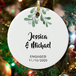 Adorno De Cerámica Personalizado involucrado<br><div class="desc">Celebra tu compromiso con estos Navidades con este elegante ornamento de árbol de Navidad. Está decorado con mistletoe acuarela. Personalizable fácil.</div>