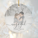 Adorno De Cerámica Primer guión gris de la foto de Personalizado comp<br><div class="desc">Conmemore su compromiso con este hermoso adorno de conservas moderno. El texto gris del carbón dice "Nuestra primera Navidad comprometida", con la palabra "comprometida" en un elegante guión de escritura a mano con flores antes y después. Reemplace la imagen de ejemplo con su foto favorita y agregue sus nombres y...</div>