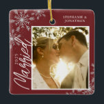 Adorno De Cerámica Primera Navidad casada con copos de nieve rojos<br><div class="desc">Este adorno navideño cuadrado es un regalo perfecto para la pareja recién casada. El diseño presenta un marco fotográfico con texto escrito a mano "Casado" y se acentúa con copos de nieve grises claros sobre un fondo rojo oscuro. Personaliza con una foto de la pareja,  sus nombres y año.</div>