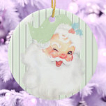 Adorno De Cerámica Sabor Vintage Green Winage Santa Christmas Tree<br><div class="desc">Este hermoso adorno de árbol de navidad de color verde suave de color pastel verde de primavera Vintage Winking Santa Navidad presenta un gráfico antiguo de Santa Claus que ha sido coloreado y reimaginado. El fondo es un patrón monocromático de banda vertical tritoniforme. El adorno de cerámica es idéntico en...</div>