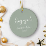 Adorno De Cerámica Sage manuscrito de pareja comprometida personaliza<br><div class="desc">Celebra tu primera Navidad como una pareja comprometida con este adorno cerámico personalizado, con un guión escrito a mano en blanco sobre un fondo verde sabio. El diseño, elegante y lúdico, añade un toque de encanto y sofisticación a la decoración de las vacaciones, lo que lo convierte en un lugar...</div>
