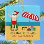 Adorno De Cerámica Sunny Beach Santa Claus Navidades Personalizados C<br><div class="desc">Este bonito Navidad personalizado adornado en julio ofrece una decoración fiesta de verano perfecta para una reunión de playa o de piscina. Hacerlo un divertido espectáculo con la temática del polo norte con Santa Claus en sus baúles de natación al lado de un paraguas de playa de rayas rojas y...</div>