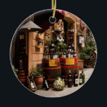 Adorno De Cerámica Tienda de vinos italiana en Montepulciano, Toscana<br><div class="desc">En esta fotografía, una romántica calle de Montepulciano, Italia, una pequeña ciudad toscana en lo alto de una colina, una bodega y una bodega exhiben botellas y barriles de vino en el exterior. Un destino increíble en Italia, esta imagen es un gran recuerdo y un regalo para un viaje a...</div>