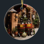 Adorno De Cerámica Tienda de vinos italiana en Montepulciano, Toscana<br><div class="desc">En esta fotografía, una romántica calle de Montepulciano, Italia, una pequeña ciudad toscana en lo alto de una colina, una bodega y una bodega exhiben botellas y barriles de vino en el exterior. Un destino increíble en Italia, esta imagen es un gran recuerdo y un regalo para un viaje a...</div>