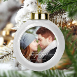 Adorno De Cerámica Tipo Bola Primera Navidad Involucrada foto blanca moderna<br><div class="desc">Conmemore su compromiso con este hermoso adorno de conservas moderno. El texto en blanco dice "Nuestra primera Navidad comprometida", con la palabra "comprometida" en elegante escritura caligráfica con toques decorativos antes y después. Reemplace la imagen de ejemplo con su foto favorita y agregue sus nombres y el año. Un filtro...</div>