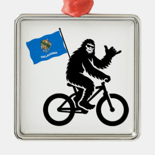 Adorno Metálico Bigfoot en bicicleta con la bandera de Oklahoma