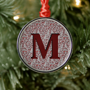 Adorno metálico con monograma floral rojo y negro