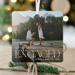 Adorno Metálico Elegante Nuestros primeros Navidades se comprometi<br><div class="desc">Hermoso adorno de navidad de compromiso fotográfico mínimo y moderno de pareja. Diseño sencillo y moderno con una plantilla de fotos completa. Personalizar este regalo con tu foto especial de compromiso, año y nombre/s. La foto tiene un overlay en la parte inferior para ayudar a la elegante tipografía blanca "Engaged"...</div>