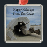 Adorno Metálico Feliz feriado cálido Pacific Coast Beach Drill<br><div class="desc">Desee unas vacaciones felices en la costa con esta imagen relajante y tranquila de una playa cálida. Este gran trozo de madera de deriva ha sido arrastrado a una playa del Océano Pacífico y poco a poco ha formado un círculo hueco en su centro. La arena marrón completa el cielo...</div>