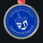 Adorno Metálico HANUKKAH SAMEACH | Chanukah | Dreidel<br><div class="desc">Elegante adorno de HANUKKAH SAMEACH con la estrella de David de color plateado falso en un patrón de baldosas y un gran dreidel blanco en el centro. El color de fondo es el azul cobalto. El texto dice HANUKKAH SAMEACH en la parte superior y UN GRAN MILAGRO SUCEDIÓ en la...</div>