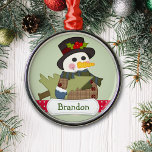 Adorno Metálico Niños educados y hombres de nieve personalizados<br><div class="desc">Un lindo muñeco de nieve vestido con sombrero de punta y abrigo de yeso lleva un árbol de Navidad. En la parte inferior hay una tira de puntos de polka roja y blanca con un cartel con el nombre blanco que contiene el nombre de su hijo u otro texto personalizado....</div>