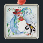 ADORNO METÁLICO SERENADE INVIERNO DE SNOWMAN Y PENGUIN<br><div class="desc">Pintado original de color pastel caprichoso,  pintado en tonos rojos azules y blancos,  muñeco de nieve y pingüino tocando violín en la nieve de invierno con flores rojas,  florido.de Bulgan Lumini (c)</div>