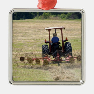 Adorno Metálico Un joven muchacho conduciendo un tractor cosechand