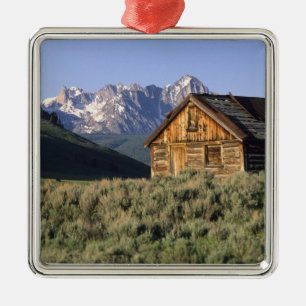 Adorno Metálico Una cabaña de troncos y las montañas Sawtooth en