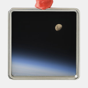 Adorno Metálico Una luna gibosa visible sobre la atmósfera de