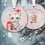 Adorno Nieta cute Kitten con regalo de Navidades<br><div class="desc">¡Aquí hay un adorable adorno de Navidad para esa nieta, hija o sobrina especial! Un gatito de rayas grises con grandes ojos azules lleva un sombrero de Santa Claus rojo y blanco y sostiene un regalo decorado con una cinta roja y un arco. La imagen se coloca en un fondo...</div>
