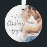 Adorno Nuestro primer guión de nombres de fotos en inglés<br><div class="desc">Nuestro primer guión de nombres de fotos de Personalizados comprometidos de Navidad. Un diseño totalmente personalizable, especialmente para celebrar la primera Navidad de la pareja feliz después de su compromiso y recuerdo del árbol en Navidad por venir. Un hermoso guión de caligrafía para el texto en la parte delantera y...</div>