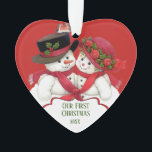 Adorno Pareja de Snowman, primera Navidad<br><div class="desc">Este adorable diseño presenta un estilo vintage,  un muñeco de nieve y una mujer con gorras vacacionales con pañuelos rojos. El texto de abajo dice: "NUESTRA PRIMERA NAVIDAD - 20XX". Esto será personalizado. La parte posterior del ornamento tiene un área donde puedes añadir tu mensaje de vacaciones.</div>