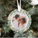 Adorno Verde dorado blanco casado y dos fotos<br><div class="desc">Este espléndido adorno de sake para recién casados presenta una florida y festiva corona de hojas de oro, vegetación de Navidades y bayas rojas en un fondo blanco moderno. Su foto personal de boda va al centro junto con las palabras "Casado y Feliz", e incluso hay un lugar para su...</div>