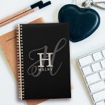 Agenda Nombre elegante con caligrafía monograma negro<br><div class="desc">Elegante y bello, este diseño de monograma muestra la inicial de su primer nombre en un simple tipo de letra serif y un elegante tipo de letra caligráfica en el fondo. Su nombre se muestra debajo de su monograma inicial en este diseño personalizado de tipografía única. Los tres elementos se...</div>