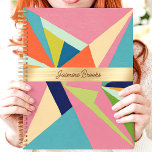 Agenda Nombre personalizado de abstracto geométrico color<br><div class="desc">Este diseño audaz muestra un patrón abstracto geométrico vibrante con tonos rosa, azul, verde y naranja vivos. La banda central de oro destaca elegantemente un nombre personalizado, creando un toque elegante y personal. Perfecto para mantenerse organizado en la escuela, en el trabajo o en la vida cotidiana, este diseño moderno...</div>