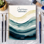 Agenda Nombre personalizado de flujo de acuarela naval 20<br><div class="desc">Sumérgete en la fluidez del arte y la organización con este fascinante planificador. Las olas acuáticas de la marina atraviesan la cubierta, lo que crea una sensación de movimiento y tranquilidad. Imagínate deslizándote por tu agenda con la misma gracia sin esfuerzo. Personalízalo con tu nombre y deja que este planificador...</div>