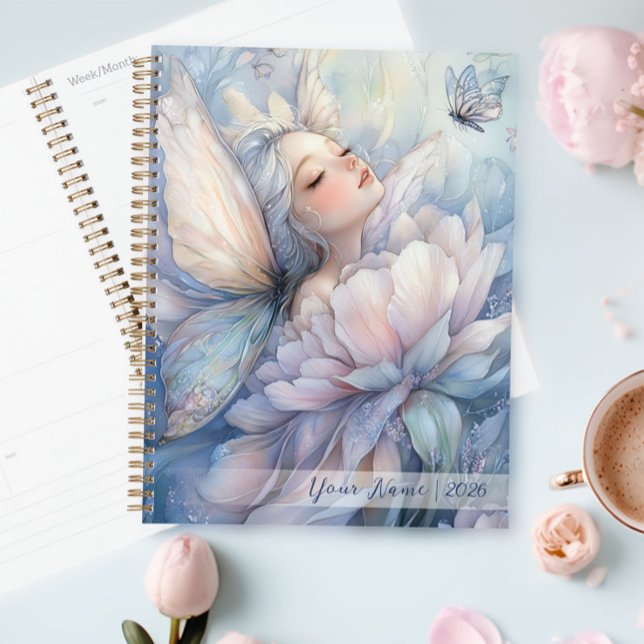 Agenda Peonía Del Amanecer (Peony Of The Dawn planner on the table, next to a cup of coffee)