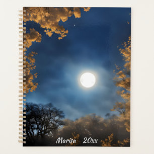 Agenda Una luna llena enmarcada por árboles