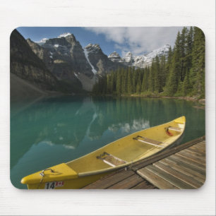 Alfombrilla De Ratón Canoe estacionado en un muelle a lo largo del lago