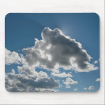 Alfombrilla De Ratón Sunlit Clouds Under Open Sky<br><div class="desc">Sunlight filters through passing clouds against a clear blue sky,  creating soft highlights and shadowed depth. A simple,  open moment captured in natural light.</div>