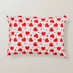 Almohada con corazones rojos sobre fondo blanco