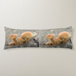 Almohada corporal con champiñones en un tronco de