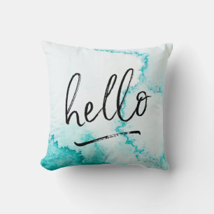 almohada de color turquesa con letras de saludo a 
