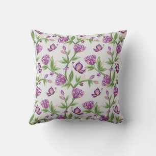 almohada de flores grisáceas y violetas con maripo