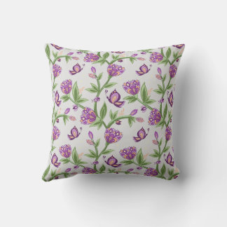 almohada de flores grisáceas y violetas con maripo
