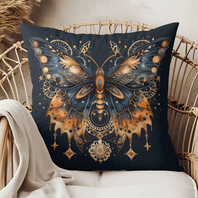 Almohada de lanzamiento de luna dorada de polilla  (Celestial Moth – Golden Moon Throw Pillow in a boho rattan armchair.)