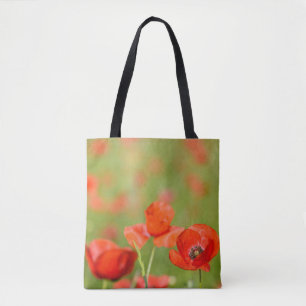 Amapolas en una bolsa de asas del campo de la