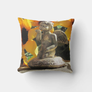 Ángel de bronce en una almohada arroja un beso