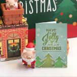 Árboles de Navidad del Libro Verde<br><div class="desc">Árboles de Navidad de papel en tonos verdes,  delineados en blanco. Los copos de nieve parecen estar cayendo sobre un fondo verde azul texturado. Tipografía verde con holly.</div>