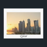 Atardecer sobre Doha, postal de texto blanco en Qa<br><div class="desc">Postal de los rascacielos en el horizonte del centro comercial de Doha,  la capital del país del Golfo Arábigo Qatar al atardecer con una frontera blanca y el texto: 'Qatar'.</div>