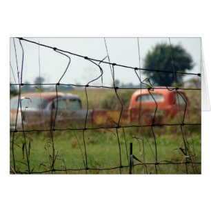 Autos y camiones se oxidan en un campo rural
