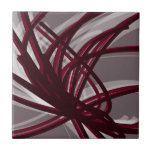 Azulejo Cinta abstracta gris y borgoñona<br><div class="desc">Diseño artístico moderno con cintas de color burdeos con acentos blancos sobre un fondo gris. Diseñado con gráficos vectoriales, puede crear su propia almohada de lanzamiento personalizada cambiando los colores de fondo y borde. Para crear su diseño personalizado, seleccione "personalizar" y desplácese a la sección de capas para ver las...</div>