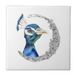 Azulejo De Cerámica Luna del purpurina de la plata del pavo real<br><div class="desc">Ésta es una pintura de la acuarela de un pavo real. El pájaro tiene colores de mezcla hermosos del azul y del verde. El pájaro está pareciendo muy noble y orgulloso. Hay falso círculo de plata del purpurina alrededor del pájaro.</div>