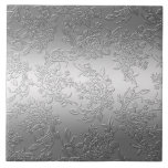 Azulejo De Cerámica Rosas y tulipanes de plata pulida Grabado en relie<br><div class="desc">Elegante diseño floral con pulverizadores de rosas de plata dimensionales,  tulipanes y follaje sobre un fondo plateado gradiente brillante. Nota: Efectos esculpidos,  grabados,  grabado en relieve y dimensionales,  de aspecto estratificado,  envejecido o erosionado,  texturas y sombras logradas digitalmente. El producto real tiene una superficie lisa.</div>