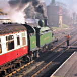 AZULEJO DE CERÁMICA TRENES DE VAPOR<br><div class="desc">Un tren de vapor bellamente restaurado y los vagones de una época pasada saliendo de la estación de tren y el conductor del motor pasa la llave antes de que se le permita seguir por el tren. Inglaterra Reino Unido.</div>